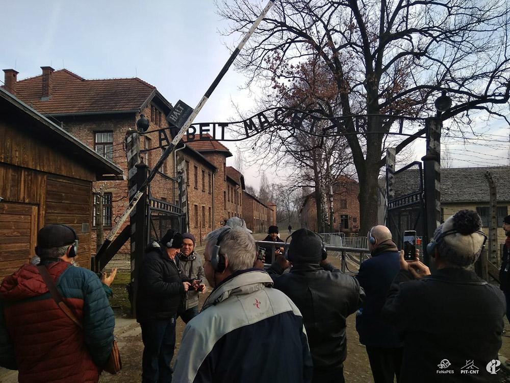 En la puerta de entrada a uno de los campos que componían el complejo (Auschwitz I) se puede leer el lema en alemán Arbeit macht frei («El trabajo libera»), con el que las fuerzas de las SS, que estaban a cargo del centro, recibían a los deportados, desde su apertura el 20 de mayo de 1940 hasta el 27 de enero de 1945, cuando fue liberado por el ejército soviético.